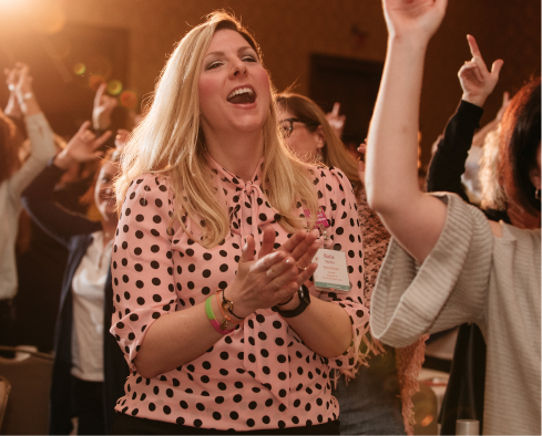 A celebration guest dances and claps for Girls on the Run